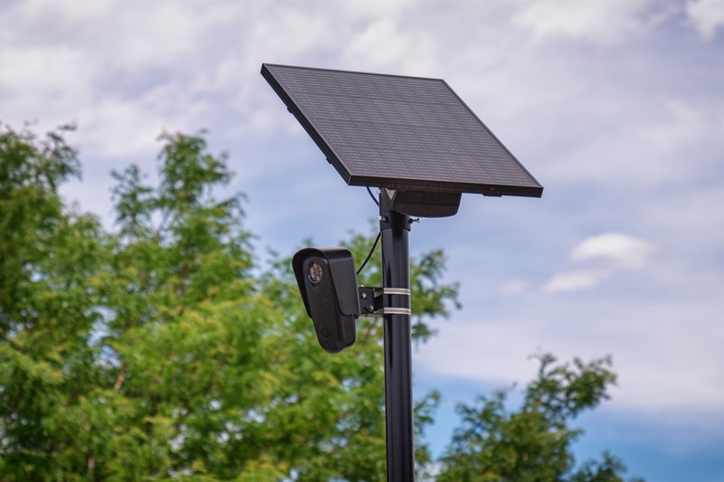 A Flock Safety automated license plate reader camera mounted on a pole outside a retail store in Aurora, Colorado