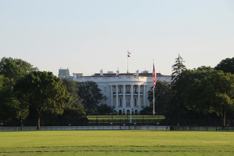 The White House surrounded by greenery under a clear blue sky