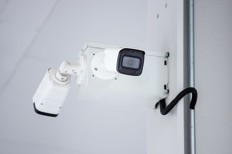A mounted surveillance camera on a wall, symbolizing domestic monitoring