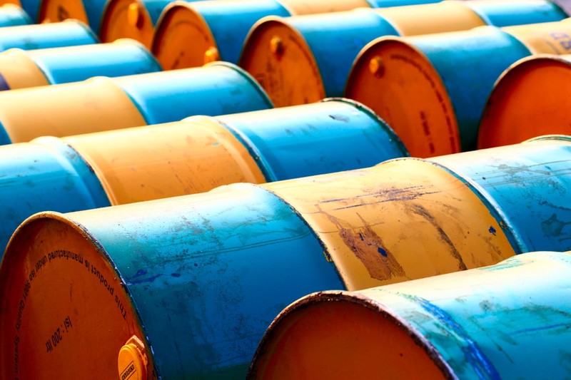 Rows of blue and yellow industrial oil barrels arranged in a storage yard