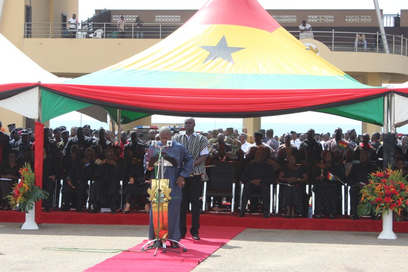 An official state ceremony at Ghana's Independence Square with a podium under a canopy in Ghana's national colors of red, gold, green, and a black star