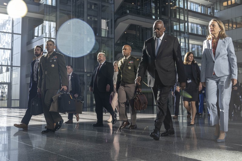 Secretary of Defense Lloyd J. Austin III walks with officials at NATO Headquarters in Brussels, Belgium